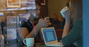 在咖啡店拥有智能手机和电脑的年轻人26秒视频