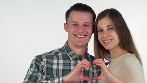 幸福的年轻夫妇用双手结为心微笑着笑容8秒视频