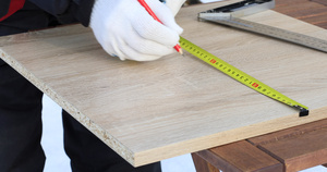 男性工人用胶带尺寸和木板上的尺头标出体积15秒视频