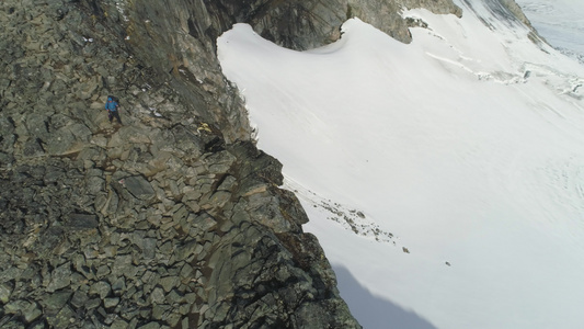 登山者正在徒步远足在悬崖附近的雪山上下行无人驾驶飞机视频