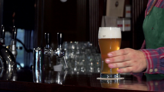 酒吧酒保倒杯美味的啤酒在酒吧放在柜台上视频