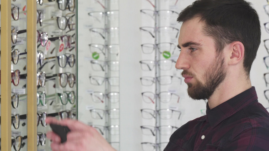 青年男子在眼罩商店拍摄眼镜相片视频