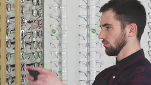 青年男子在眼镜店挑选眼镜13秒视频