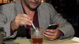 成年男子使用智能电话同时在威士忌中加冰块11秒视频