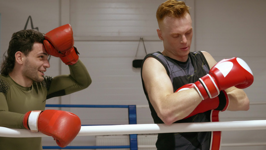 两名男子拳击手在搏击俱乐部进行强化训练后戴着拳击手套视频