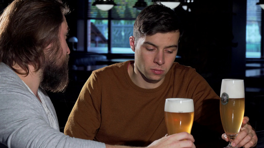 和朋友一起在酒吧喝酒的年轻情绪低落的男人视频