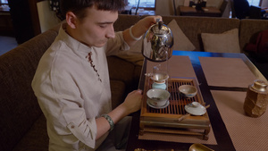 在传统仪式举行时用干茶在碗中的水壶里倒热水的男子19秒视频