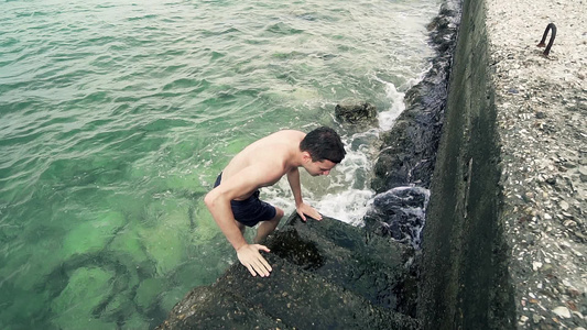 人类在码头的老水泥楼梯上从海水中流出慢动作视频