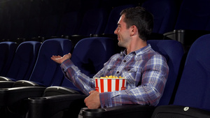 快乐的英俊男人愉快地笑着坐在电影院里9秒视频