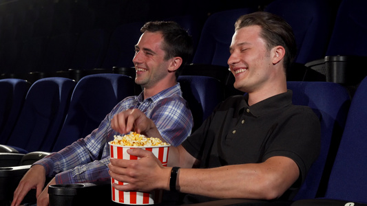 两个男性朋友在电影院看喜剧时笑着笑视频