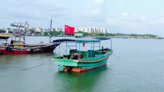 4K航拍停在海边的渔船国旗红旗飘飘视频素材视频