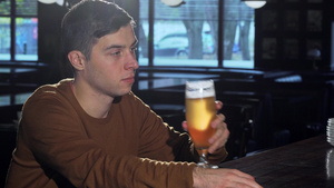 年轻人在喝杯子里的美味啤酒后笑着向相机微笑14秒视频