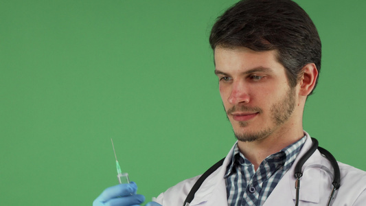 持有绿背景注射针筒的男性医务工作者视频