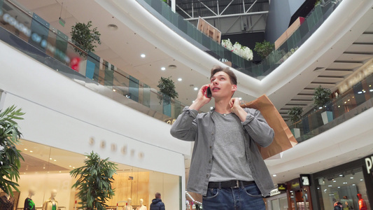青年男子在购物中心电话上说话视频