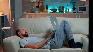 男人在笔记本电脑上工作时在电视风中睡着了15秒视频
