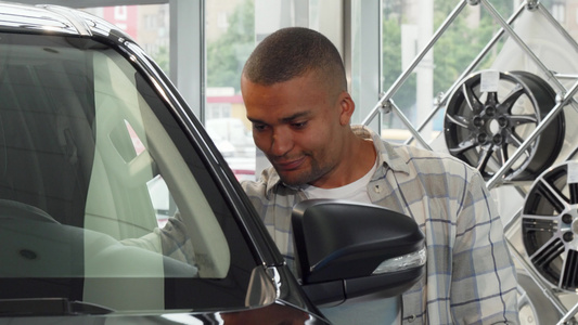 英俊的非洲年轻男人在经销店微笑着拿着车钥匙视频