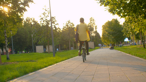 男子穿着黄色衬衫骑自行车14秒视频