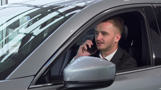 商人在电话里聊天坐在一辆新汽车上视频