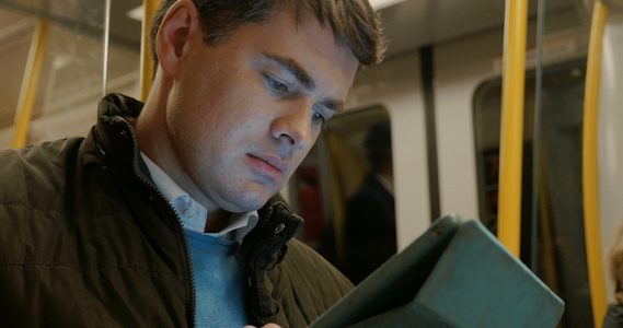 男人在地铁列车中使用平板电脑视频