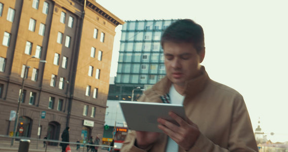 男人用平板电脑走在城市里视频
