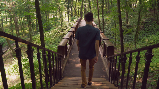一个人从楼梯上下来走在一个木头桥道上在前期视频