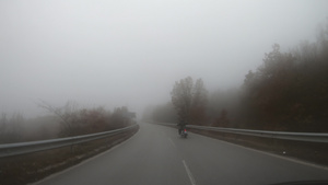 英俊的青年男子骑自行车在恶劣天气下乘摩托车到户外带雾30秒视频