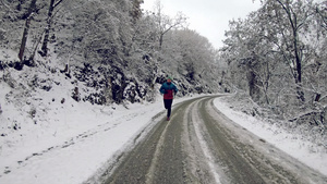 星期天早上在雪覆盖的乡村道路上穿着冬季夹克的男子在29秒视频