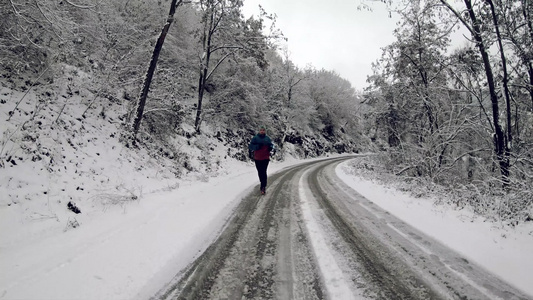 青年成年单身男子在第一雪过后冬季天在公园或森林足迹视频