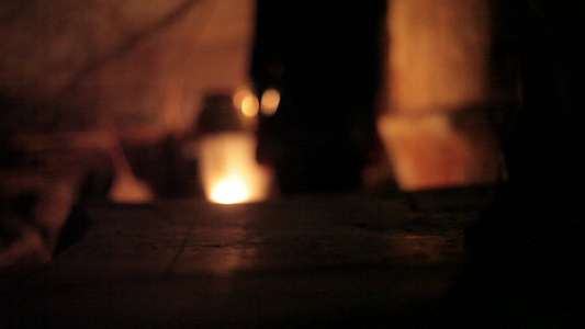 人类雕像在黑暗的阴暗地点使用蜡烛走下楼梯用蜡烛照亮视频