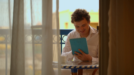 男人用笔记本电脑在阳台上喝茶视频