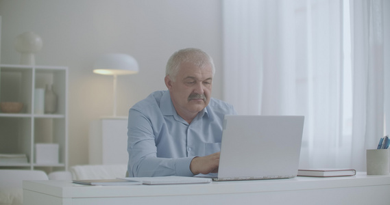 男子在用笔记本电脑工作时感到过度延长和颈部疲劳为放松视频