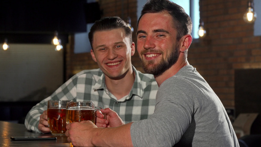 快乐的男人微笑着对着镜头笑同时在酒吧喝啤酒视频