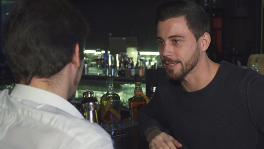 年轻男性朋友在酒吧一起喝酒时聊天时说话;和视频