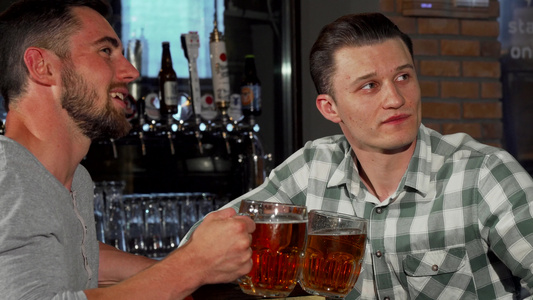 快乐的男性朋友在酒吧看比赛边喝啤酒边喝酒视频