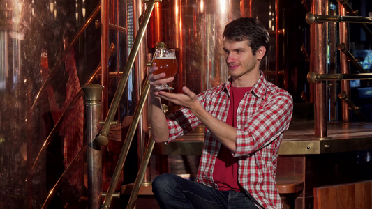 年轻男性酿酒者检查新鲜酿啤酒在他的酿酒厂工作视频