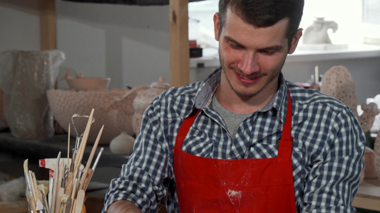 英俊又帅又快乐的男性陶匠享受在工作室工作视频