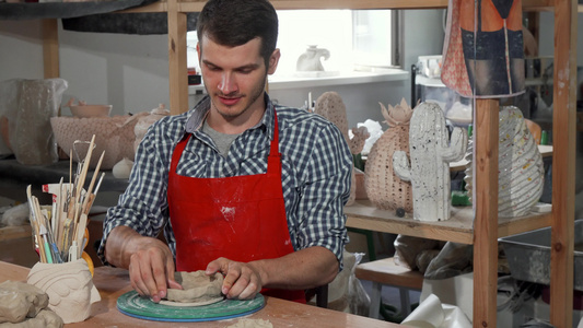 年轻男性陶瓷艺术家在工作时微笑着向相机微笑视频