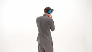 跳舞听音乐站在镜头前身穿灰色运动服戴着蓝色无线耳机19秒视频