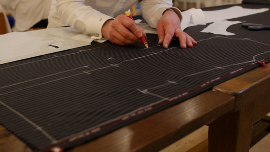 男裁缝在工作室绘制图案的手男人的手在羊毛织物上用粉笔视频