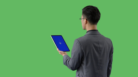 4k绿幕蓝幕合成抠像穿西装的商务男性使用平板电脑背影视频