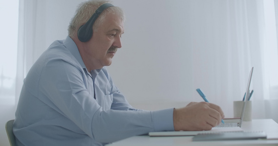 老年男性律师通过互联网咨询客户使用笔记本电脑在线聊天视频