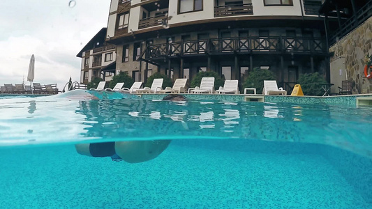 在豪华的维拉游泳池里游水高极圆顶半水下风景慢动作视频