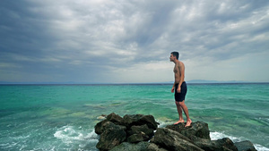 孤独的男性少年在海岩和航海地平线上站立15秒视频