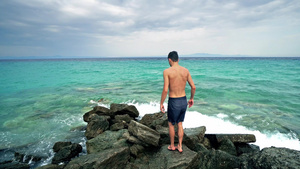 孤独的男性少年在海岩和航海地平线上站立19秒视频