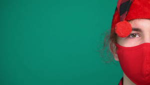 穿着圣塔帽男孩的肖像戴着红色医疗面具看着摄像机11秒视频