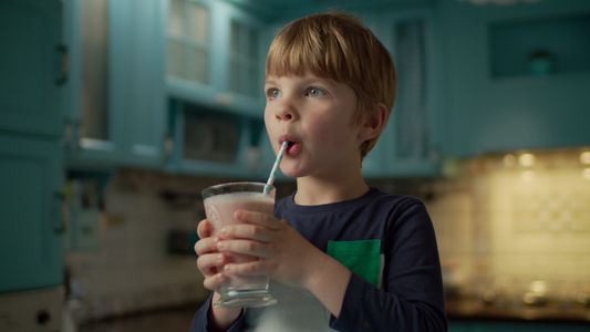 金发学龄前男孩的肖像喜欢在蓝厨房里喝白莓冰淇淋孩子视频