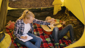 男孩和女孩少年在夏季远足时在野营帐篷里休息旅游女孩10秒视频