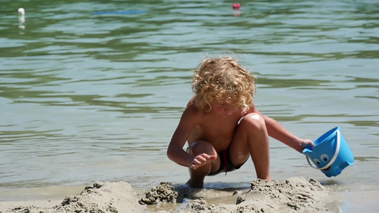 金发小男孩在海滩玩视频