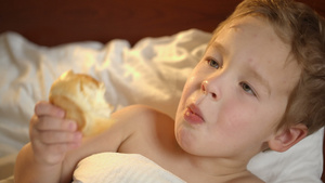床上吃面包的小男孩14秒视频