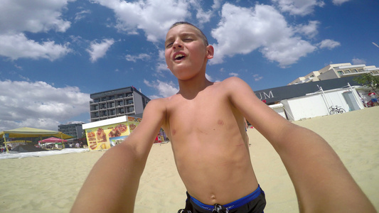 快乐的男孩在海滩上旋转用自拍镜头享受自然和度假生活视频